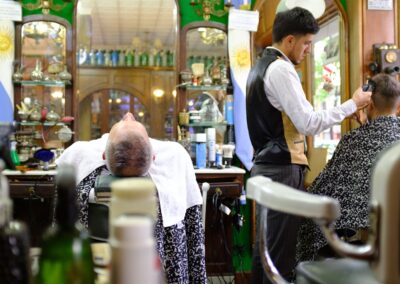 A classic barbershop in Buenos Aires with a barber styling a client's hair, surrounded by vintage decor.