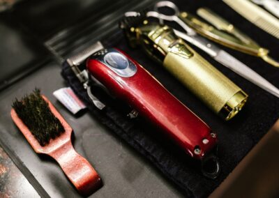 Close-up of professional barber tools including clippers and scissors arranged neatly for a haircut.